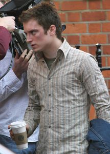 Elijah Wood carries a cup of coffee along a street in central London while filming his new movie The Yank with co-star Chris Hunnam. In the movie he plays a recently expelled Harvard student who travels to London and gets embroiled in the passion and excitement of the English football culture.Picture by Ian Miller<br>  <B>Ref:  IMUK MGUK 310304 A  EXCLUSIVE</B><P><B>Splash News and Pictures</B><br>Los Angeles:310-821-2666<br>New York:212-619-2666<br>London:207-107-2666<br>photodesk@splashnews.com